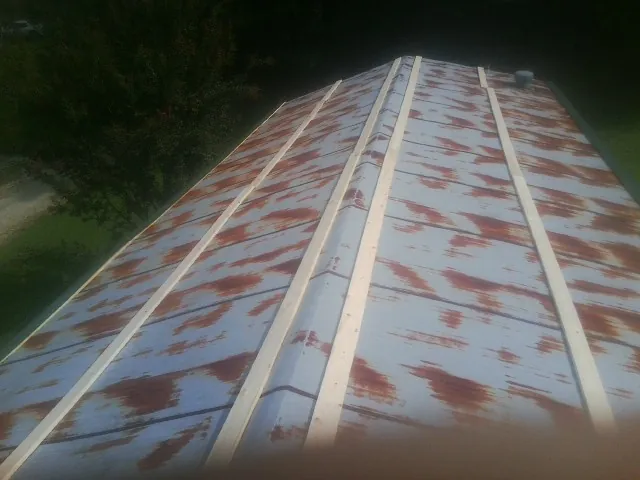 Rusted metal roof panels with new wood purlins before replacement — Storm Damage Roof Repair in Mc Queeney by Roofing Brothers